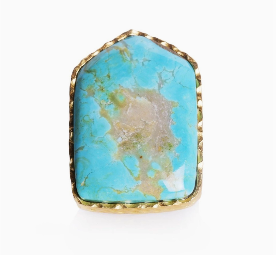 close up of a turquoise ring cut into a shield shape and placed in an 18K gold-plated sterling silver. 